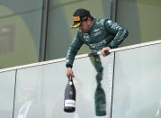 Aston Martin driver Fernando Alonso, of Spain, drops a bottle to teammates following his second-place finish in the Formula One Canadian Grand Prix auto race Sunday, July 18, 2023, in Montreal. (Christinne Muschi/The Canadian Press via AP)