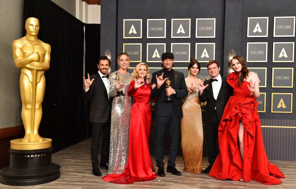 Eugenio Derbez, from left, Sian Heder, Marlee Matlin, Troy Kotsur, Emilia Jones, Daniel Durant and Amy Forsyth, winners of the award for best picture for "CODA," pose in the press room while signing "I love you" at the Oscars on March 27, 2022, at the Dolby Theatre in Los Angeles. The three Oscar wins for the film "CODA" has provided an unprecedented feeling of affirmation to people in the Deaf community.