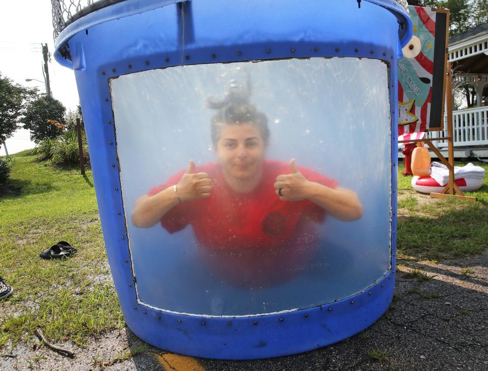 Riverside Rest Home employee Jodi Brown gives a thumbs up as she hits the water in the dunk tank during the home's Carnival Day July 19, 2023.