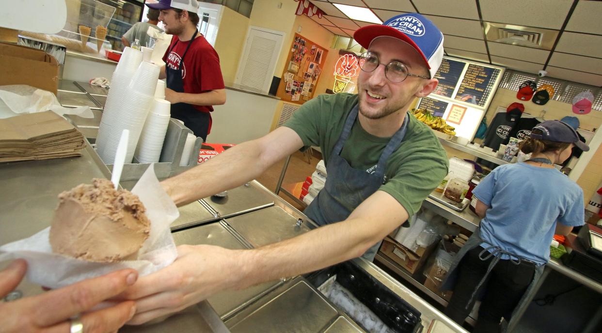 Zach Fargher hands a customer a cup of chocolate ice cream at Tony’s Ice Cream Tuesday afternoon, July 19, 2022.