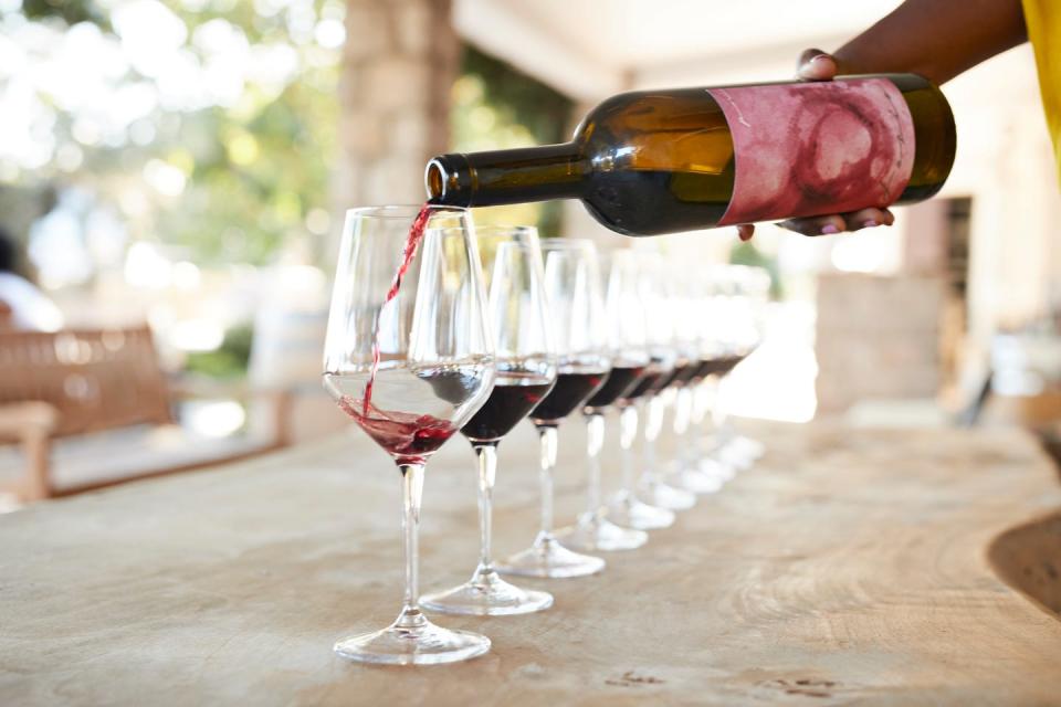 hand of female owner pouring red wine