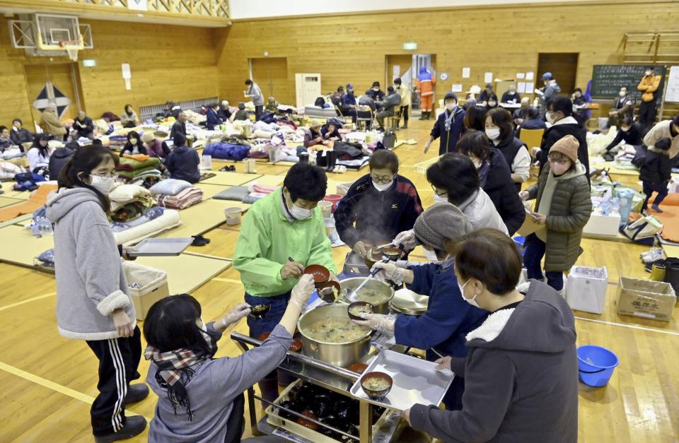 Local residents in the quake-hit area, wait for food distribution at a shelter in Anamizu, Ishikawa prefecture, Sunday, Jan. 7, 2024. Rescue teams worked through snow to deliver supplies to isolated hamlets Monday, a week after a powerful earthquake hit western Japan. (Kyodo News via AP)