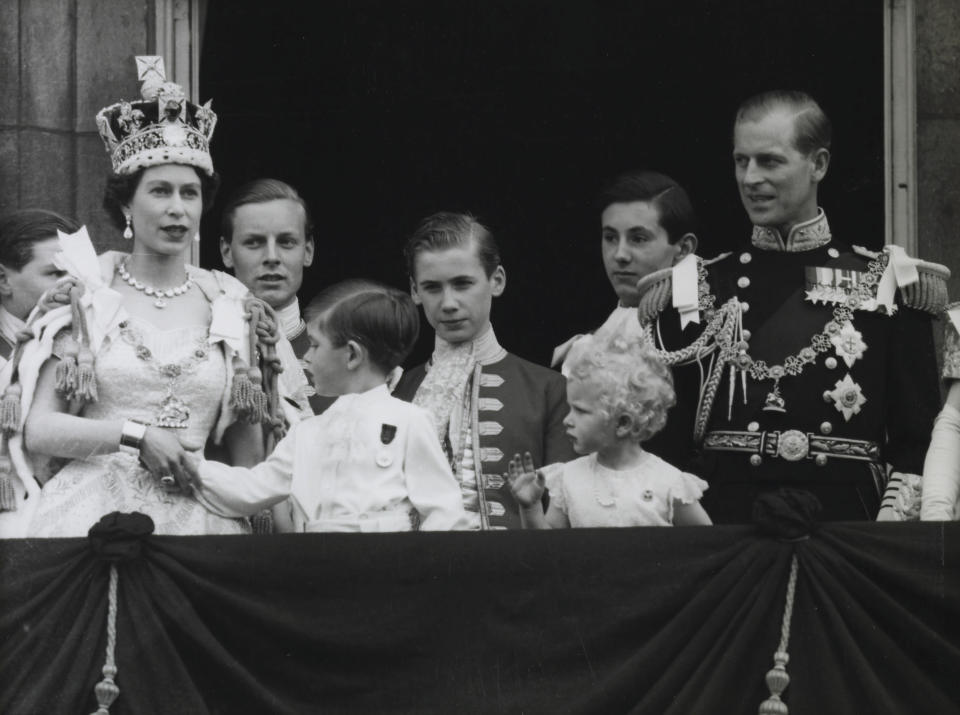 Queen Elizabeth holding Prince Charles's hand as she wears the armillis designed for her 1953 coronation. (PA)