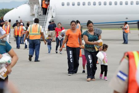 Women and their children walk on the tarmac after being deported from the U.S., at the Ramon Villeda international airport in San Pedro Sula, in this July 14, 2014 handout provided by the Honduran Presidential House. REUTERS/Presidential House/Handout via Reuters