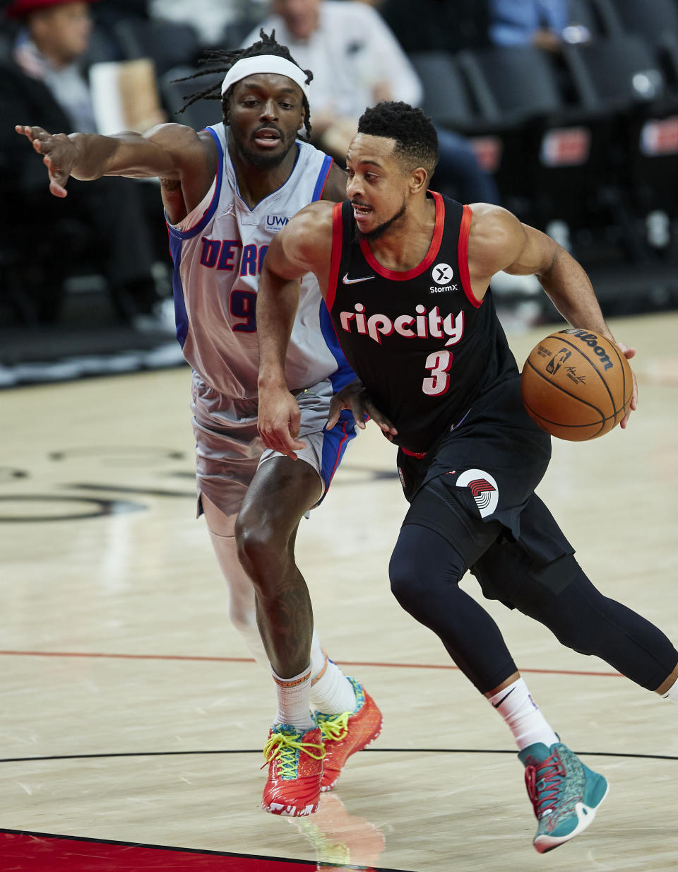 Portland Trail Blazers guard CJ McCollum, right, drives to the basket past Detroit Pistons forward Jerami Grant during the second half of an NBA basketball game in Portland, Ore., Tuesday, Nov. 30, 2021. (AP Photo/Craig Mitchelldyer)