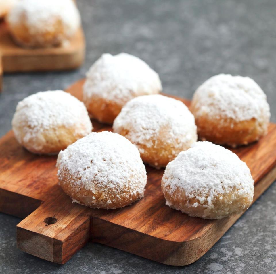 mexican wedding cookies on a wooden board