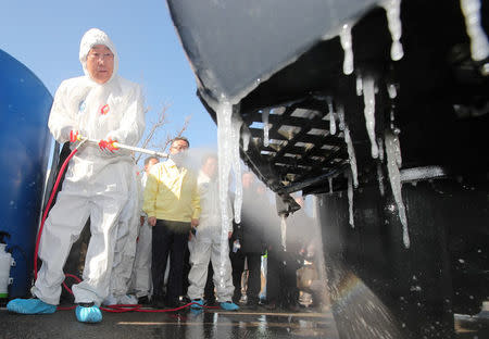 Former U.N. secretary-general Ban Ki-moon disinfects a vehicle at a checkpoint in Eumseong, South Korea, January 14, 2017. Kim Do-hoon/Yonhap via REUTERS