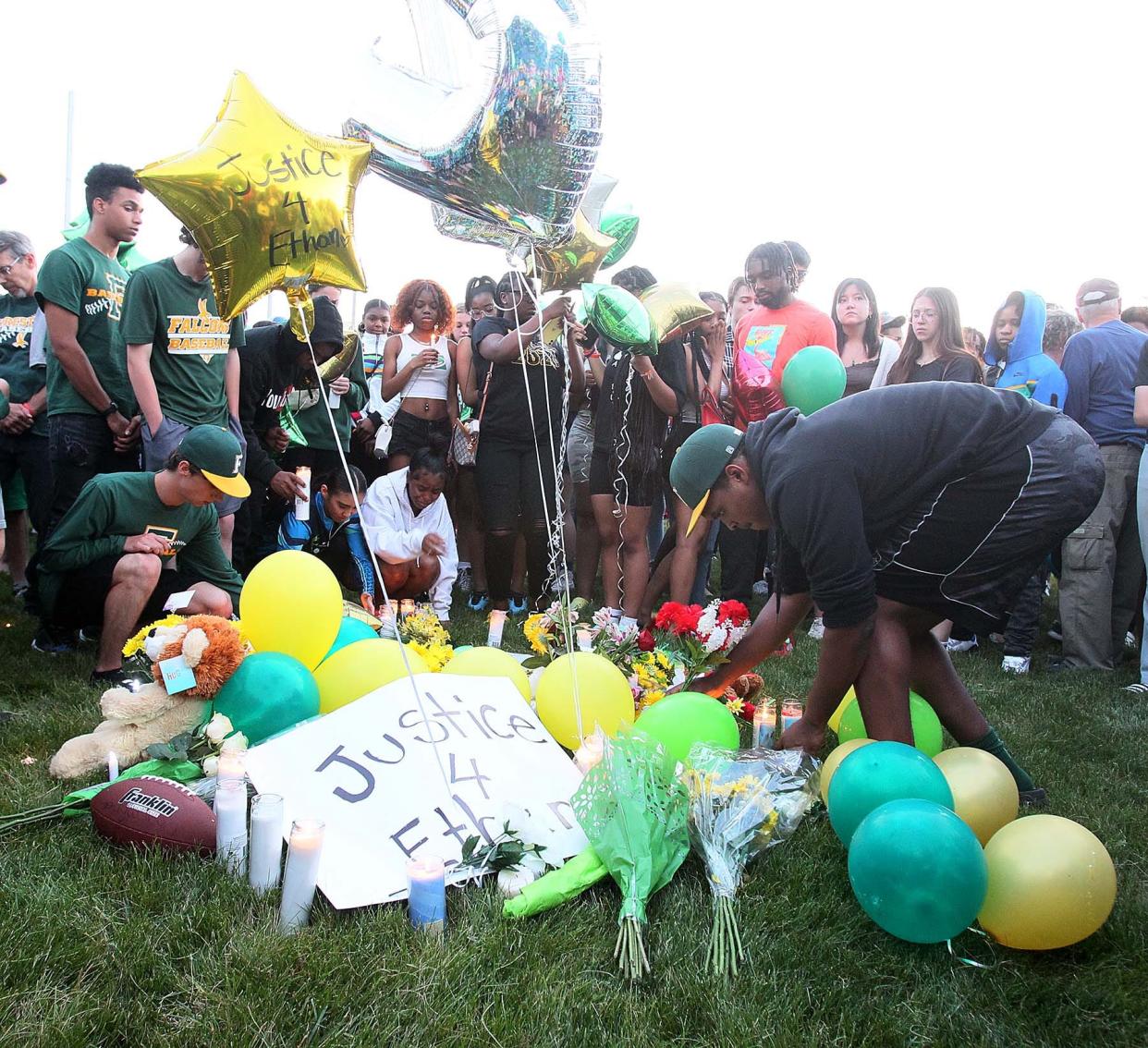 Family and friends gather at the baseball field on Friday evening at Firestone High School in Akron for a vigil for Ethan Liming, 17, a much loved and admired Firestone student who played baseball and football. Liming was killed in an altercation near the basketball courts at the I Promise School on Thursday night.