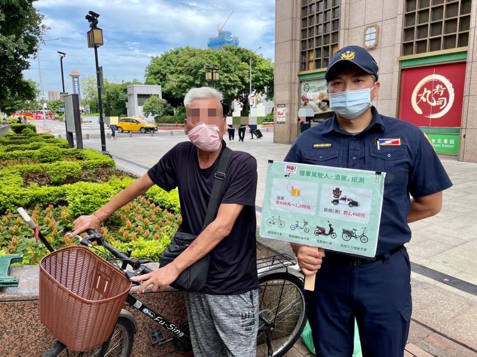 圖片說明：臺北市保安警察大隊警員洪維聰向民眾宣導慢車駕駛人酒駕、拒測罰責。(記者宋紹誠翻攝)