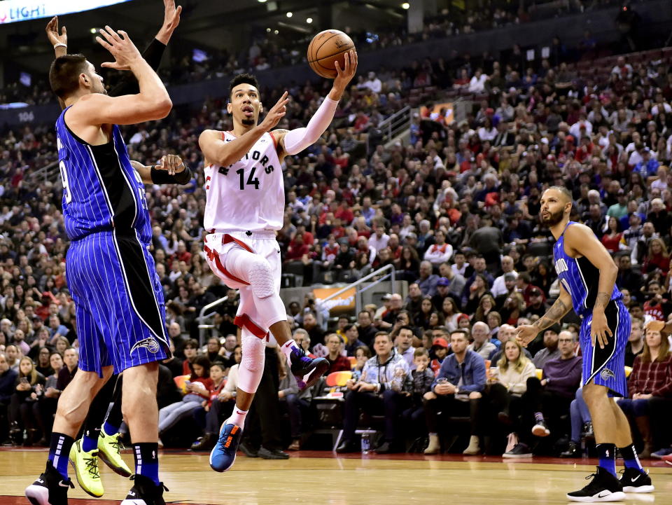 Toronto Raptors guard Danny Green (14) goes for the layup as Orlando Magic center Nikola Vucevic (9) and Evan Fournier (10) look on during first-half NBA basketball game action in Toronto, Sunday, Feb. 24, 2019. (Frank Gunn/The Canadian Press via AP)