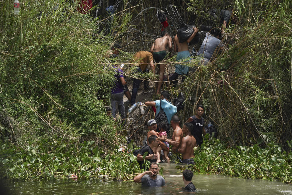 Migrants walk up the bank of the Rio Grande river, seen from Matamoros, Mexico, Wednesday, May 10, 2023. The U.S on May 11 will begin denying asylum to migrants who show up at the U.S.-Mexico border without first applying online or seeking protection in a country they passed through, according to a new rule released May 10. (AP Photo/Fernando Llano)