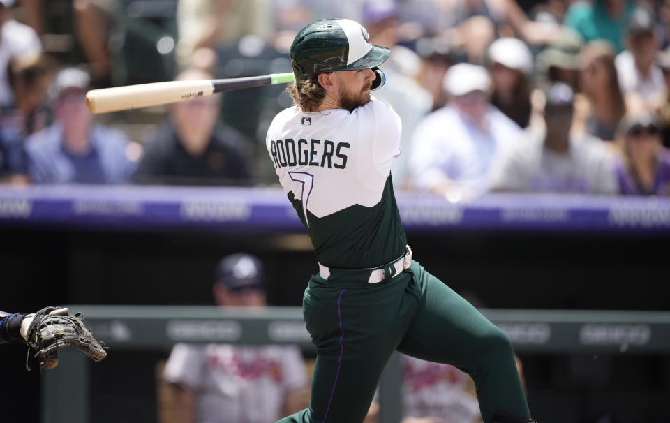 Colorado Rockies' Brendan Rodgers follows the flight of his double to drive in two runs off Atlanta Braves starting pitcher Charlie Morton in the first inning of a baseball game Sunday, June 5, 2022, in Denver. (AP Photo/David Zalubowski)