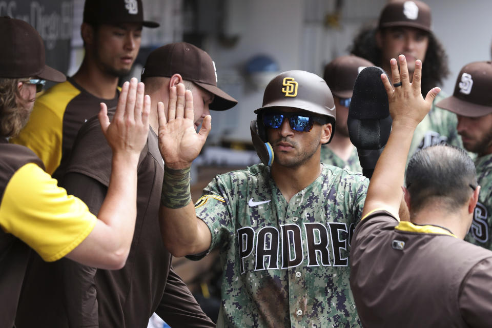 San Diego Padres' Trent Grisham is congratulated by teammates after scoring on a single by Jake Cronenworth against the Minnesota Twins in the sixth inning of a baseball game, Sunday, July 31, 2022, in San Diego. (AP Photo/Derrick Tuskan)