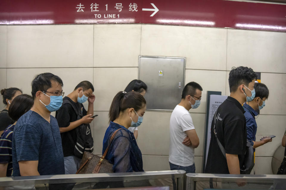 People wearing face masks to help protect against COVID-19 walk through a subway station during the morning rush hour in Beijing, Wednesday, Aug. 4, 2021. China's worst coronavirus outbreak since the start of the pandemic a year and a half ago escalated Wednesday with dozens more cases around the country, the sealing-off of one city and the punishment of its local leaders. (AP Photo/Mark Schiefelbein)