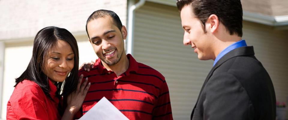 Real Estate: Agent Shows Information To Couple