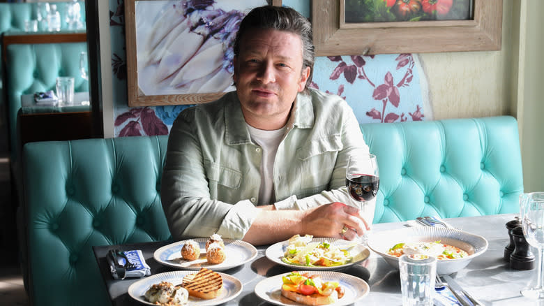Jamie Oliver sits at a table