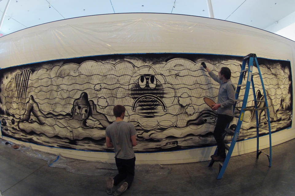 In this Tuesday, Feb. 12, 2013 photo, Ryan Travis Christian, right, and assistant Travis Fish apply charcoal to a wall installation at the Contemporary Art Museum in Raleigh, N.C. The Chicago artist completely reworked this wall-sized drawing several days into his first museum exhibition. (AP Photo/Allen Breed)