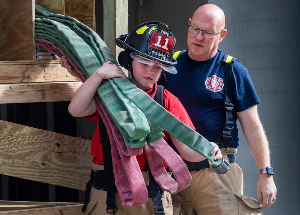 Newburgh Volunteer Fire Department’s Cydney Marx, left, pulls down line with the guidance of her father Captain Courtney Marx during a training session Saturday, Sept. 16, 2023.