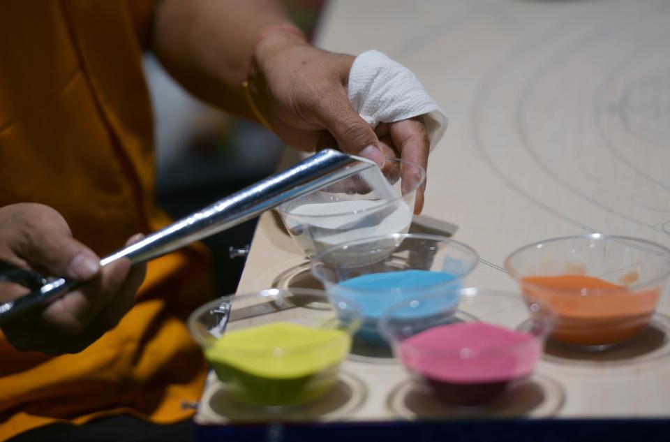 Preparing colored sand for the mandala