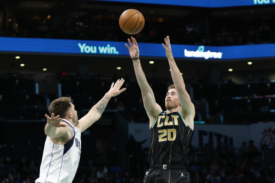 Charlotte Hornets forward Gordon Hayward (20) shoots over Dallas Mavericks guard Luka Doncic during the first half of an NBA basketball game in Charlotte, N.C., Sunday, March 26, 2023. (AP Photo/Nell Redmond)