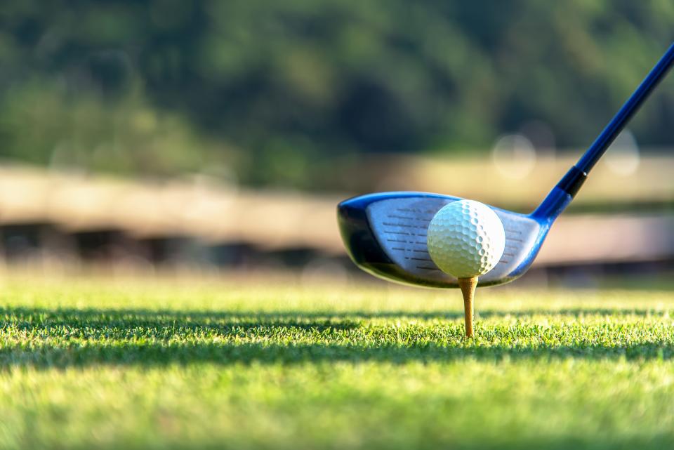 Getty Images
Close up golf ball and driver, player doing golf swing tee off on the green sunset evening time, presumably does exercise. Healthy and Lifestyle Concept.