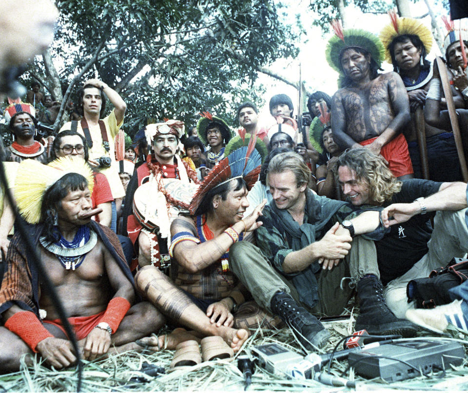FILE - British musician and activist Sting, second from right, and Belgian filmmaker Jean-Pierre Dutilleux, right, talk with Menkragnoti Kayap Indigenous Chiefs Paulo Payakan, second from left, and Chief Raoni Metuktire, left, during a five-day meeting in Altamira, Brazil, Feb. 21, 1989. For five decades, the Amazonian tribal chief Raoni Metuktire and Belgian film director Jean-Pierre Dutilleux enlisted presidents and royals, even Pope Francis, to improve the lives of Brazil’s Indigenous peoples and protect their lands. The pair befriended celebrities and movie stars. Sting, the musical legend, was one of their greatest champions. (AP Photo/Miro Nunes, File)