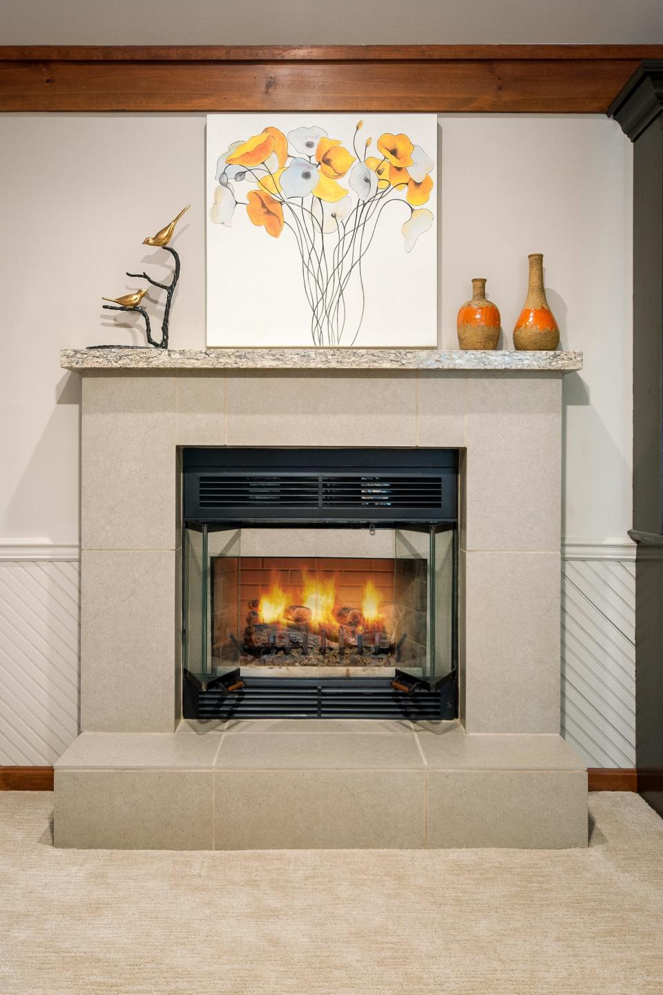 The old dark creek rock fireplace was replaced with tile and a custom-made, light-colored granite mantel in this redesigned living room in Louisville.