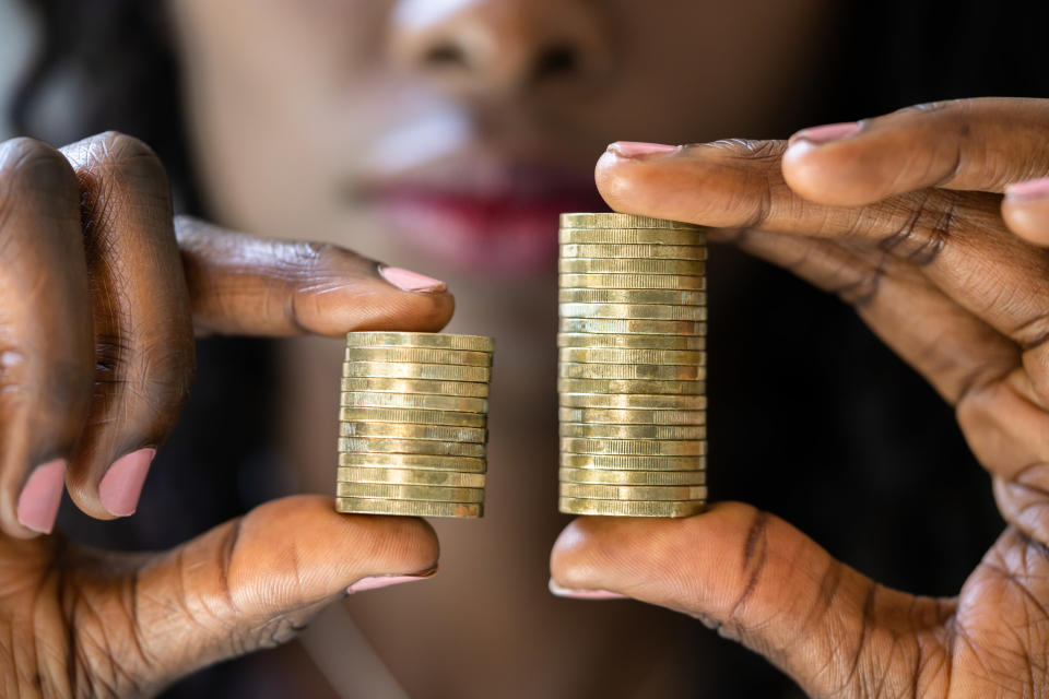 Person holding two unequal stacks of coins