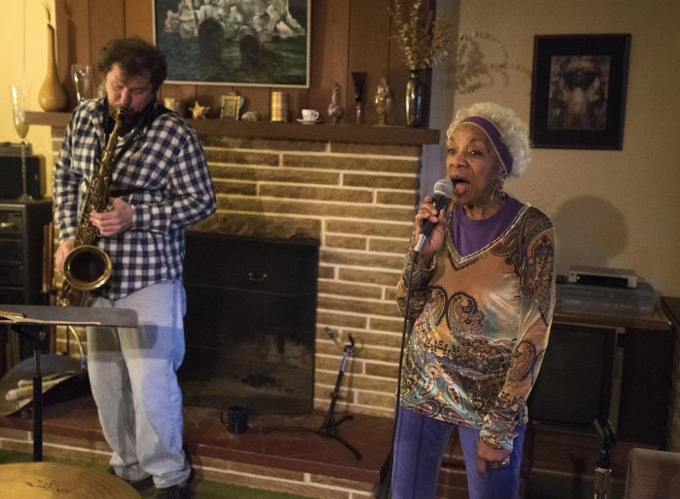 Betty Douglas rehearsing in her Rochester Township home with saxophonist Rex Trimm.