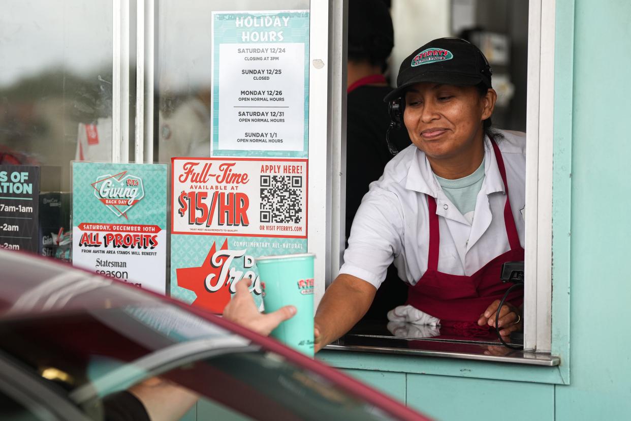 Cashier Romelia Lopez hands a drink to a customer in the drive-thru at P. Terry's Burger Stand's Ben White location during the restaurant's annual Giving Back Day last year. On Saturday, all P. Terry's profits will be donated to the Statesman's Season for Caring program.