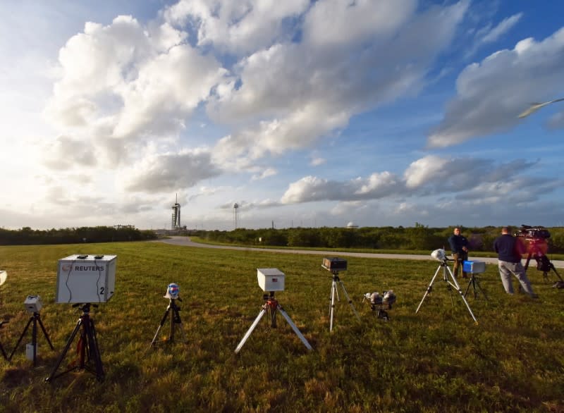 Remote cameras line a field near Pad 39A at Kennedy Space Center where the SpaceX Crew Dragon sits atop a Falcon 9 booster rocket