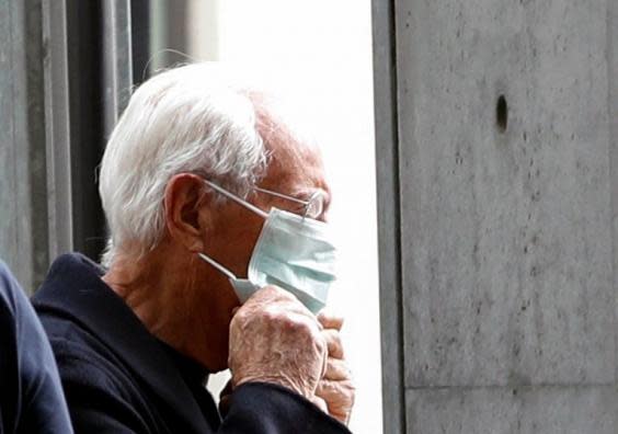 Giorgio Armani puts on a face mask as he arrives at the venue of his Autumn/Winter 2020 fashion show in Milan (23 February 2020) (REUTERS/Alessandro Garofalo)