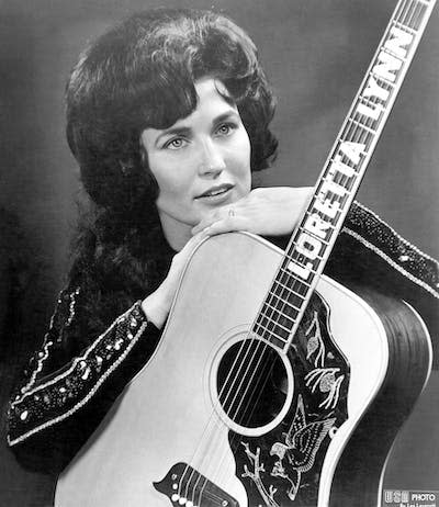 Loretta Lynn hizo de las preocupaciones de las mujeres estadounidenses de a pie el centro de su obra. <a href="https://www.gettyimages.com/detail/news-photo/loretta-lynn-poses-for-a-portrait-holding-a-guitar-that-has-news-photo/74282205?phrase=loretta%20lynn&adppopup=true" rel="nofollow noopener" target="_blank" data-ylk="slk:Michael Ochs Archives/Getty Images;elm:context_link;itc:0;sec:content-canvas" class="link ">Michael Ochs Archives/Getty Images</a>