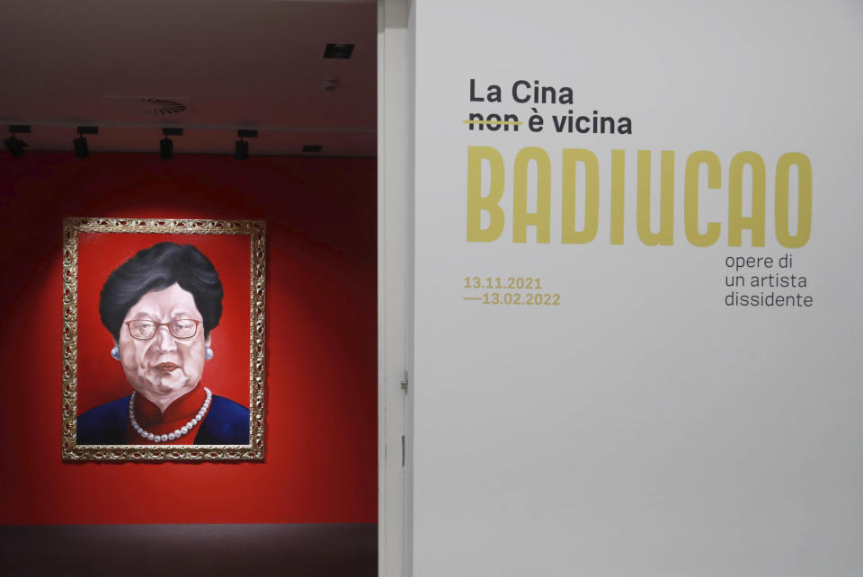 Writing on a panel reads in Italian "China is not near, BADIUCAO, works of a dissident artist" at the opening of artist Badiucao's exhibition in the Santa Giulia Museum, in Brescia, Saturday, Nov. 13, 2021. A provocative exhibit by dissident Chinese artist Badiucao opened Saturday in the industrial northern Italian city of Brescia despite pressure from the Chinese embassy in Rome to cancel it. A letter from the embassy included veiled economic threats, noting Italy’s trade with China, in a bid to prevent the first solo exhibit by Badiucao — the pseudonym used by the artist whose work takes aim at China's policies and human rights record. (AP Photo/Felice Calabro')