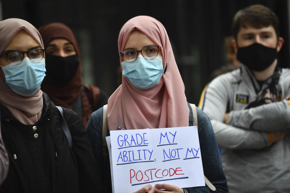 People take part in a protest in Westminster in London over the government's handling of A-level results, Friday, Aug. 14, 2020. Thousands of school-leaving children in Britain have been left distraught after finding out that they were handed lower-than-expected grades. The government is under growing pressure to address the question of how to fairly award students grades in the absence of actual exams. (Victoria Jones/PA via AP)