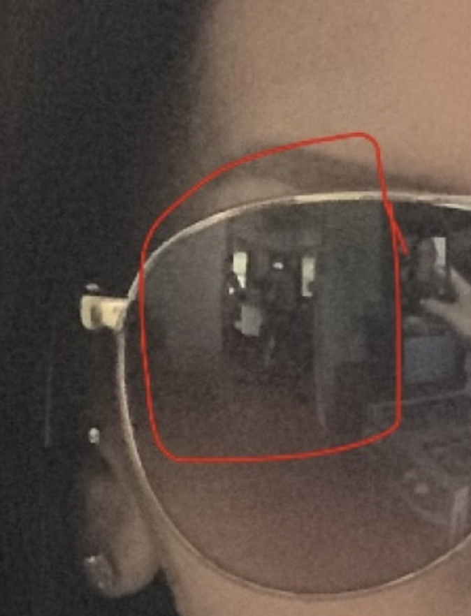 The woman's sunglasses reflection with a red circle around the two boys. Source: Quora