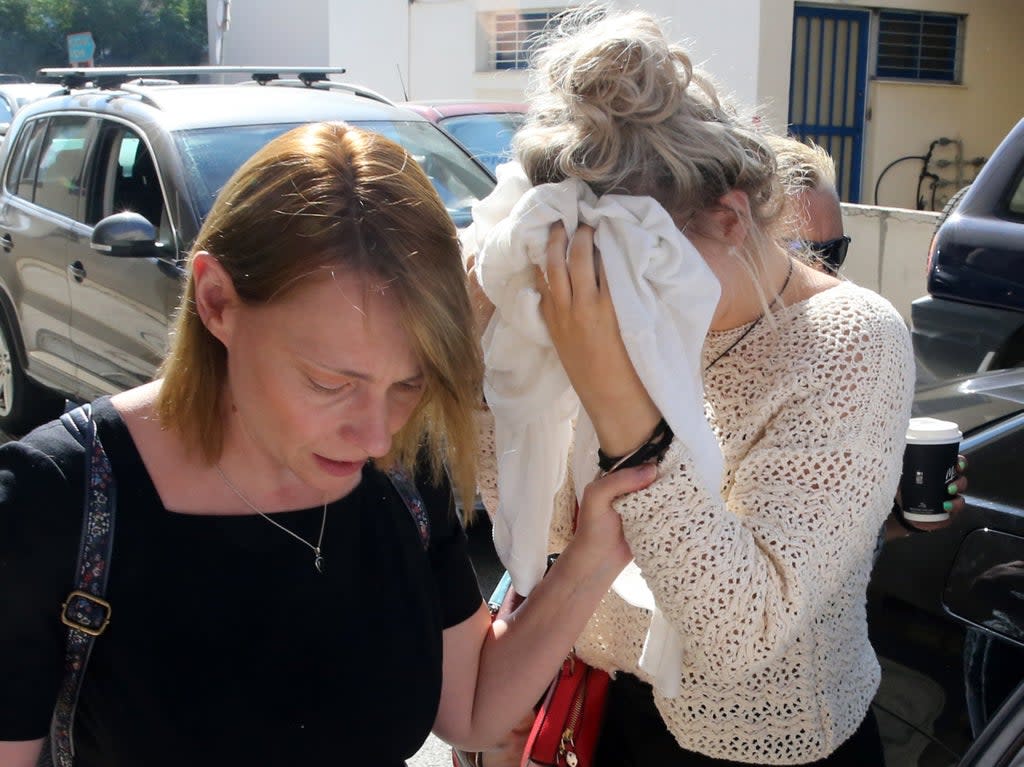 The unnamed British woman, then 19, covers her face at Famagusta District Court in Paralimni, on 2 October 2019 (Katia Christodoulou/EPA)