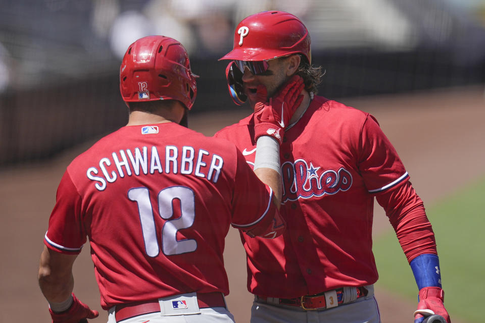 Philadelphia Phillies' Kyle Schwarber (12) celebrates with teammate Bryce Harper after hitting a home run during the first inning of a baseball game against the San Diego Padres, Wednesday, Sept. 6, 2023, in San Diego. (AP Photo/Gregory Bull)