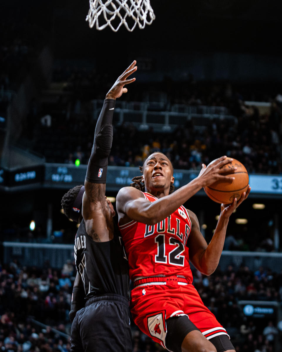 Chicago Bulls' Ayo Dosunmu (12) shoots against Brooklyn Nets' Dennis Schroder, left, during the first half of an NBA basketball game in New York, Friday, March 29, 2024. (AP Photo/Peter K. Afriyie)