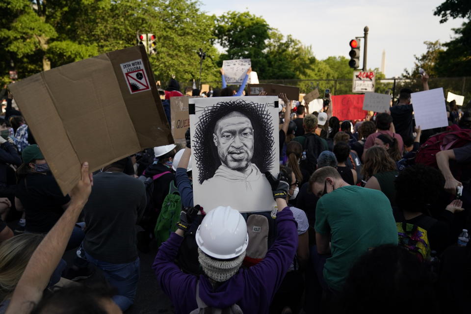 Un manifestante sostiene un dibujo de George Floyd durante una protesta cerca de la Casa Blanca, en Washington, el martes 2 de junio de 2020. (AP Foto/Evan Vucci)