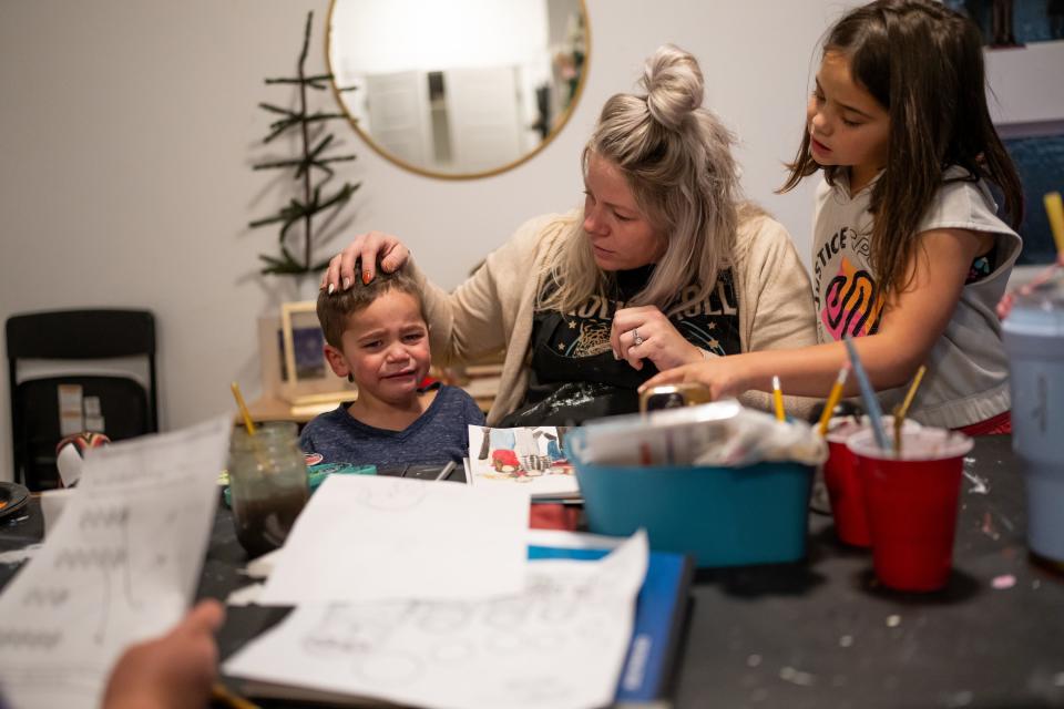 Jessica Palu comforts her son Joey, 3, after he got upset that he couldn’t go play outside at their home in Eagle Mountain on Tuesday, Nov. 28, 2023. At right is Palu’s daughter Fine, 7. | Spenser Heaps, Deseret News