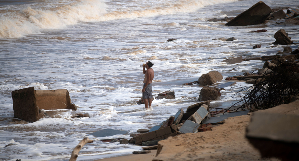 A man standing in the sea at Atafona.