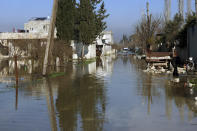 A car drives through the al-Tlul village flooded after a devastating earthquake destroyed a river dam in the town of Salqeen near the Turkish border, Idlib province, Syria, Thursday, Feb. 9, 2023. (AP Photo/Ghaith Alsayed)