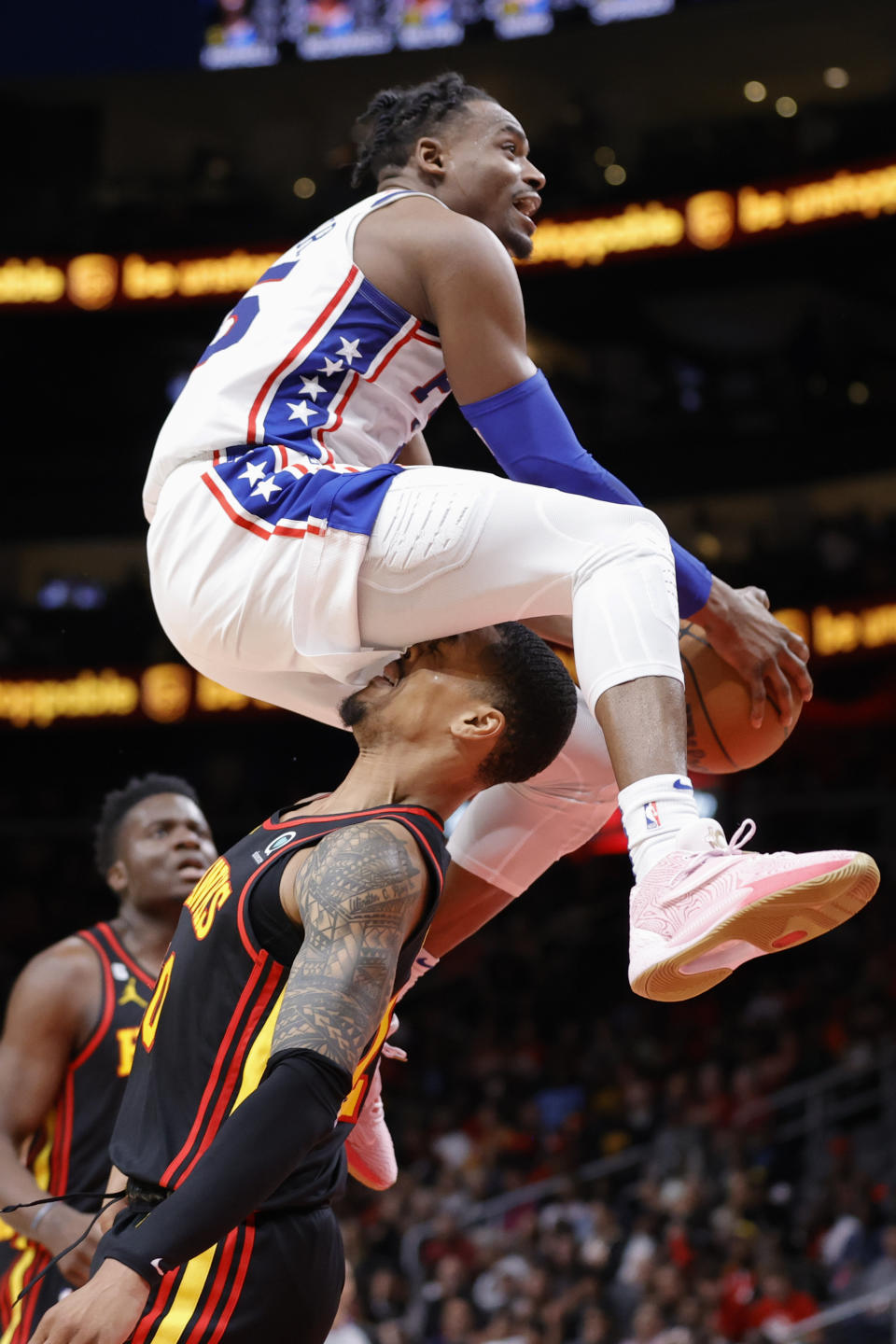 Philadelphia 76ers forward Danuel House Jr. goes to the basket above Atlanta Hawks forward John Collins during the second half of an NBA basketball game Friday, April 7, 2023, in Atlanta. Collins was called for a foul. (AP Photo/Alex Slitz)