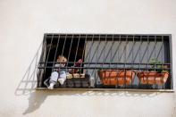 Palestinian boy Belal Daraghma, 3, looks out as he sits on the window of his family apartment in Tubas in the Israeli-occupied West Bank