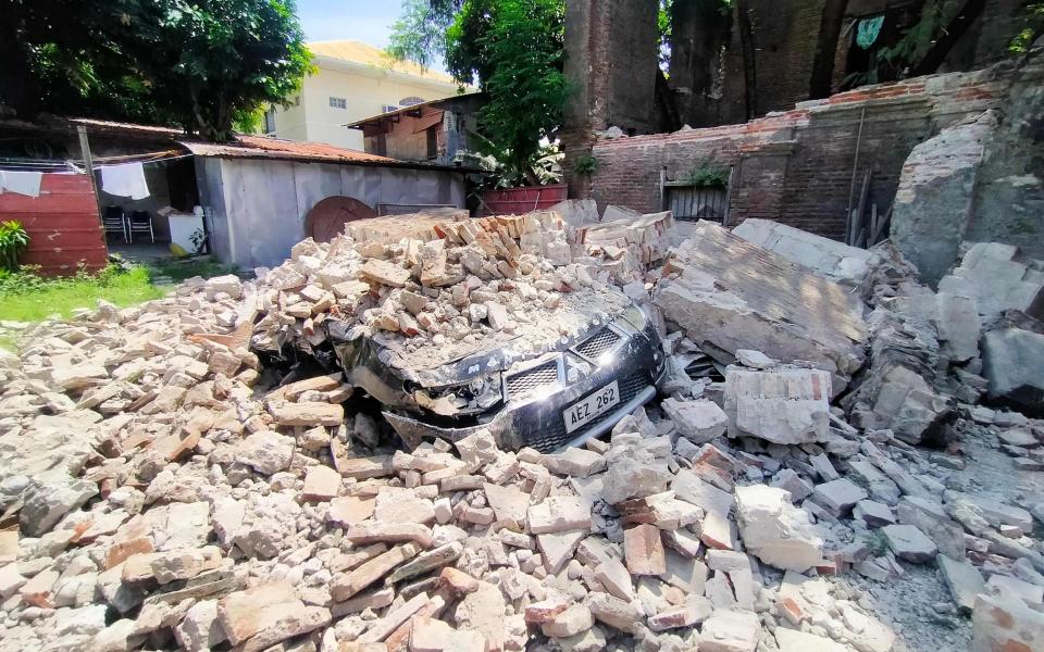 A car is buried under debris from a ruined old house in Vigan city - RICARDO RAGUINI 