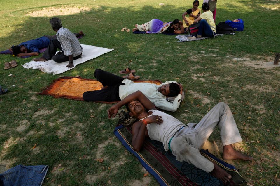 People rest in the shade of a tree on a hot summer afternoon in Lucknow in the central Indian state of Uttar Pradesh, Thursday, 28 April 2022 (AP)