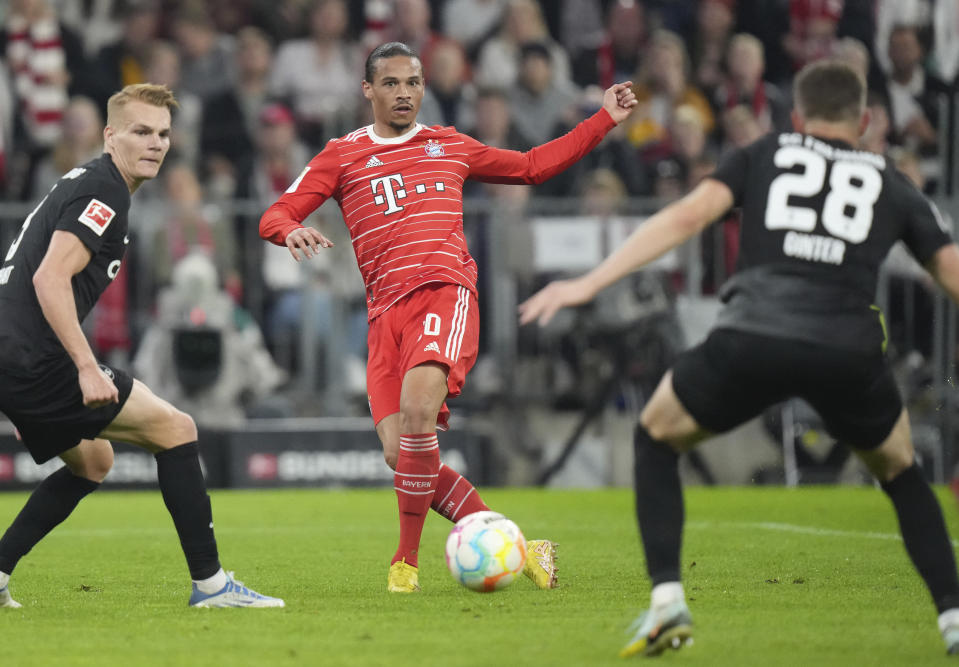 Bayern's Leroy Sane, centre, controls the ball ahead of Freiburg's Matthias Ginter during the German Bundesliga soccer match between FC Bayern Munich and SC Freiburg at the Allianz Arena in Munich, Germany, Oct. 16, 2022. (AP Photo/Matthias Schrader)