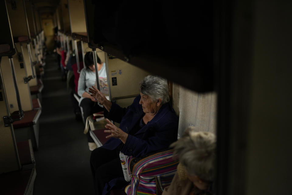 Lyubov Chudnyk, right, fleeing from heavy shelling, waits aboard an evacuation train to depart Pokrovsk train station, in Pokrovsk, eastern Ukraine, Sunday, May 22, 2022. Civilians fleeing areas near the eastern front in the war in Ukraine Sunday described scenes of devastation as their towns and villages came under sustained attack from Russian forces. (AP Photo/Francisco Seco)