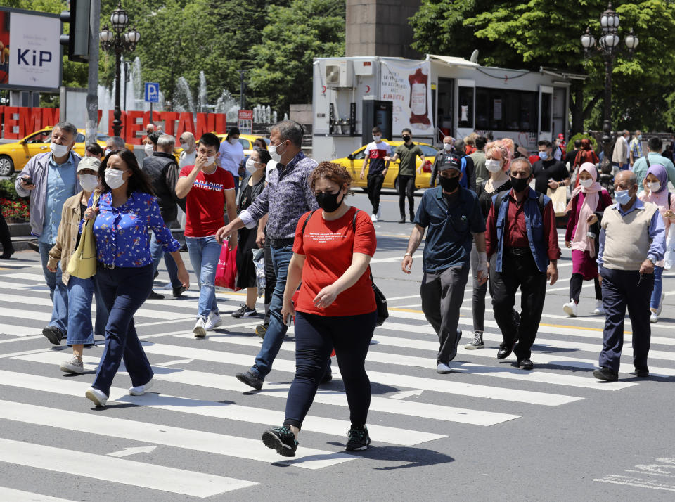 People wearing face masks to protect against the spread of coronavirus, walk in the city's historical part of Ulus, in Ankara, Turkey, Thursday, June 18, 2020. Turkish authorities have made the wearing of masks mandatory in three major cities to curb the spread of COVID-19 following an uptick in confirmed cases since the reopening of many businesses.(AP Photo/Burhan Ozbilici)